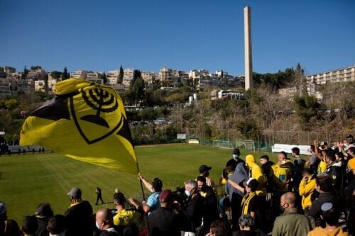 Fãs do Beitar Jerusalem Football Club agitam a bandeira do time durante um treino em Jerusalém, em 11 de dezembro de 2020. [Amir Levy/Getty Images]