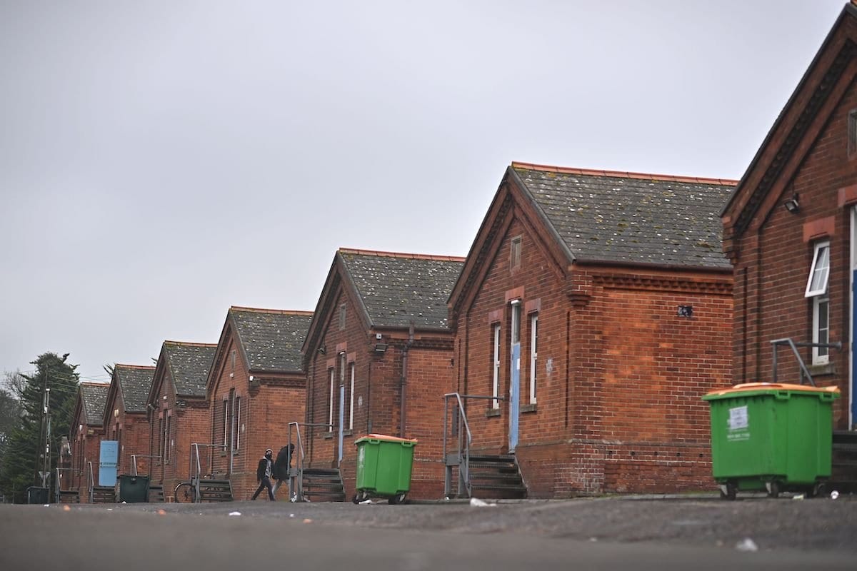 Um migrante caminha no Napier Barracks, um antigo quartel militar usado para abrigar requerentes de asilo em Folkestone, sudeste da Inglaterra, em 1º de fevereiro de 2021. [Ben Stansall/AFP via Getty Images]
