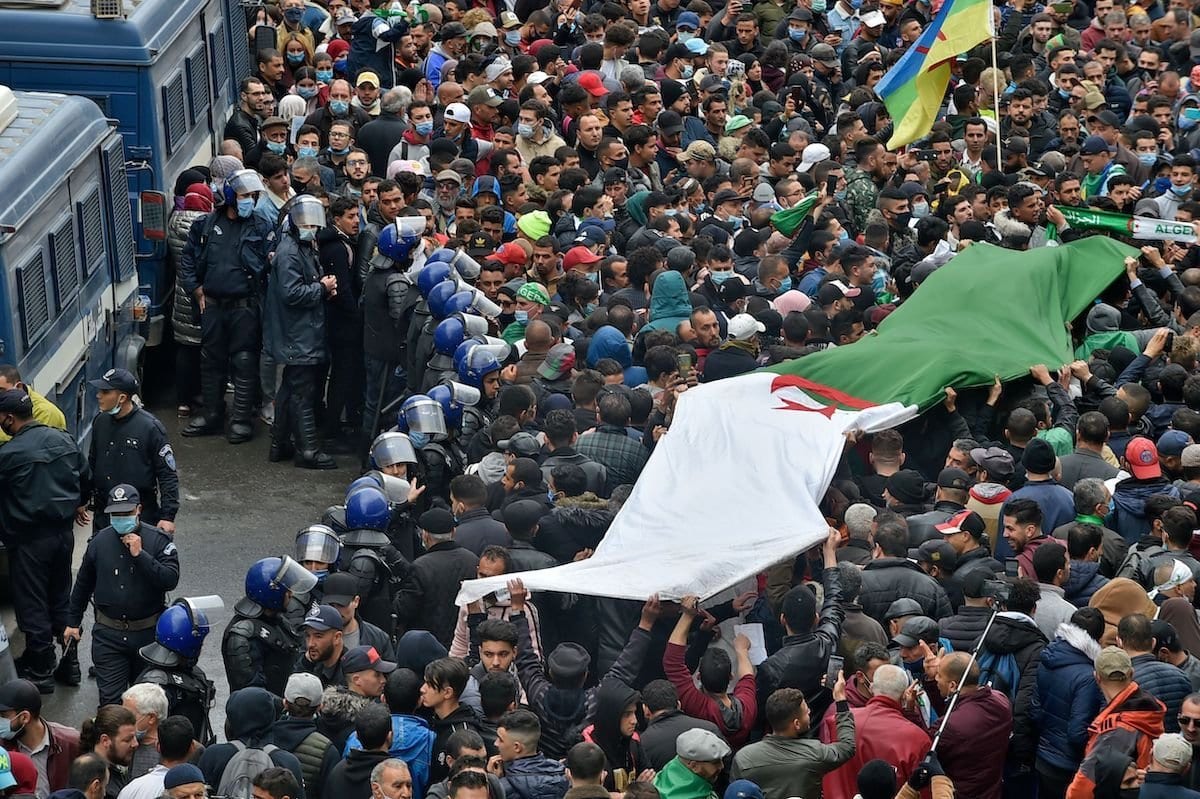 Os argelinos se manifestam na capital Argel, em 22 de fevereiro de 2021, marcando o segundo aniversário do movimento de protesto antigoverno “Hirak” do país. [Ryad Kramdi/AFP via Getty Images]
