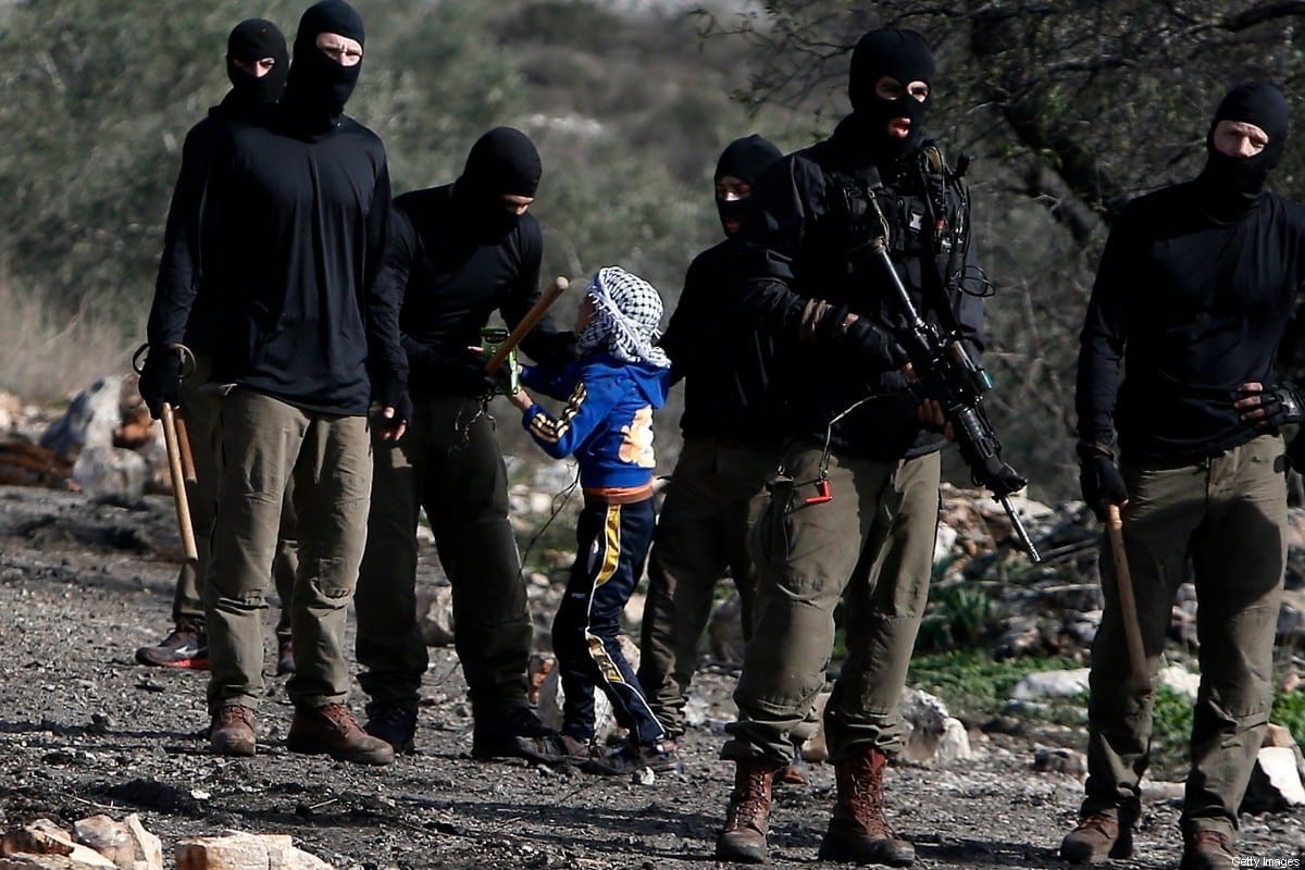 Membros mascarados das forças de segurança de Israel detêm um menino palestino ao reprimir um protesto contra a expropriação de terras palestinas pela ocupação israelense, na aldeia de Kafr Qaddum, perto de Nablus, Cisjordânia ocupada, 23 de dezembro de 2016 [Jaafar Ashtiyeh/AFP/Getty Images]