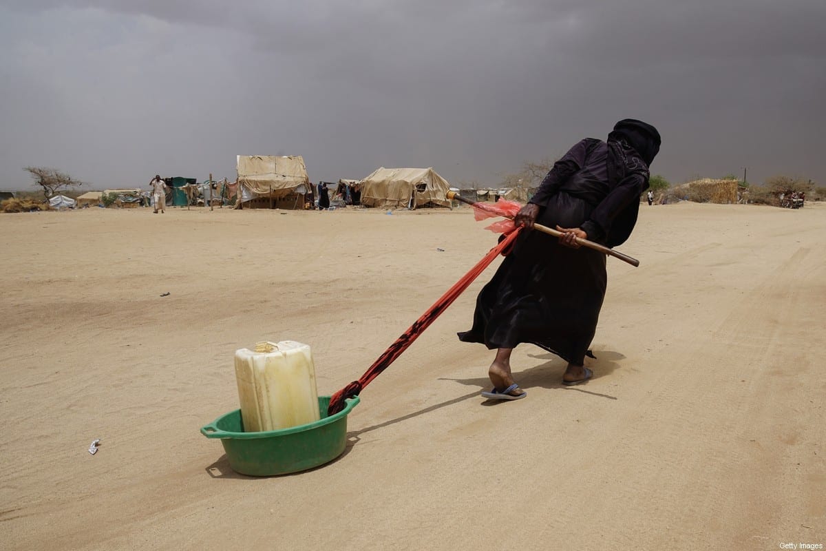 Refugiada iemenita arrasta um galão de água à sua tenda, no campo de deslocados internos de Abs, situado a 40 km da frente de batalha com a Arábia Saudita [Giles Clarke/UNOCHA/Getty Images]