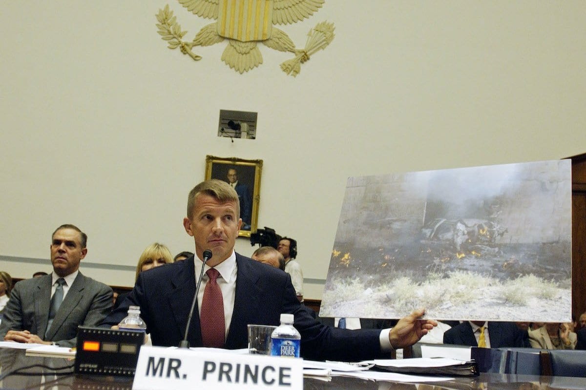 Erik Prince, presidente do Prince Group, LLC e Blackwater USA, mostra a foto de um SUV Blackwater atingido por um carro-bomba suicida em Mosul, Iraque, em 2005, como ele testemunhou durante uma audiência do Comitê de Supervisão da Câmara e Reforma do Governo no Capitólio em Washington, DC, contratação de segurança privada no Iraque e no Afeganistão em 2 de outubro de 2007 . [Bill Putnam / Bloomberg via Getty Images]
