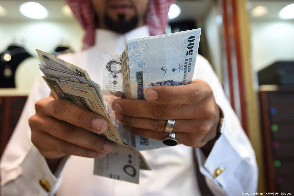 Homem conta notas de riyal em um mercado de Riad, capital da Arábia Saudita, 3 de outubro de 2016 [Fayez Nurdeline /AFP/Getty Images]