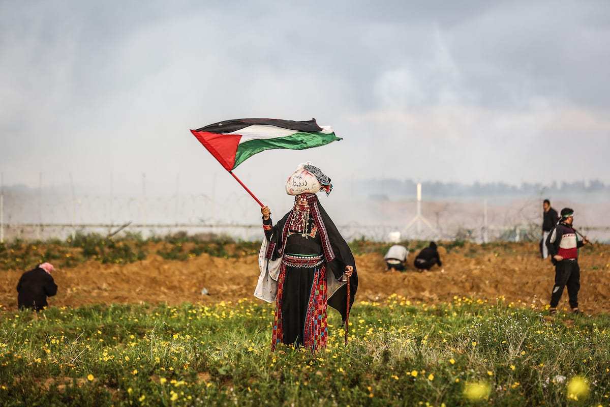 Mulher agita uma bandeira palestina durante a manifestação da "Grande Marcha do Retorno" perto da fronteira Israel-Gaza, em Khan Yunis, Gaza em 01 de março de 2019. (Mustafa Hassona/Agência Anadolu)