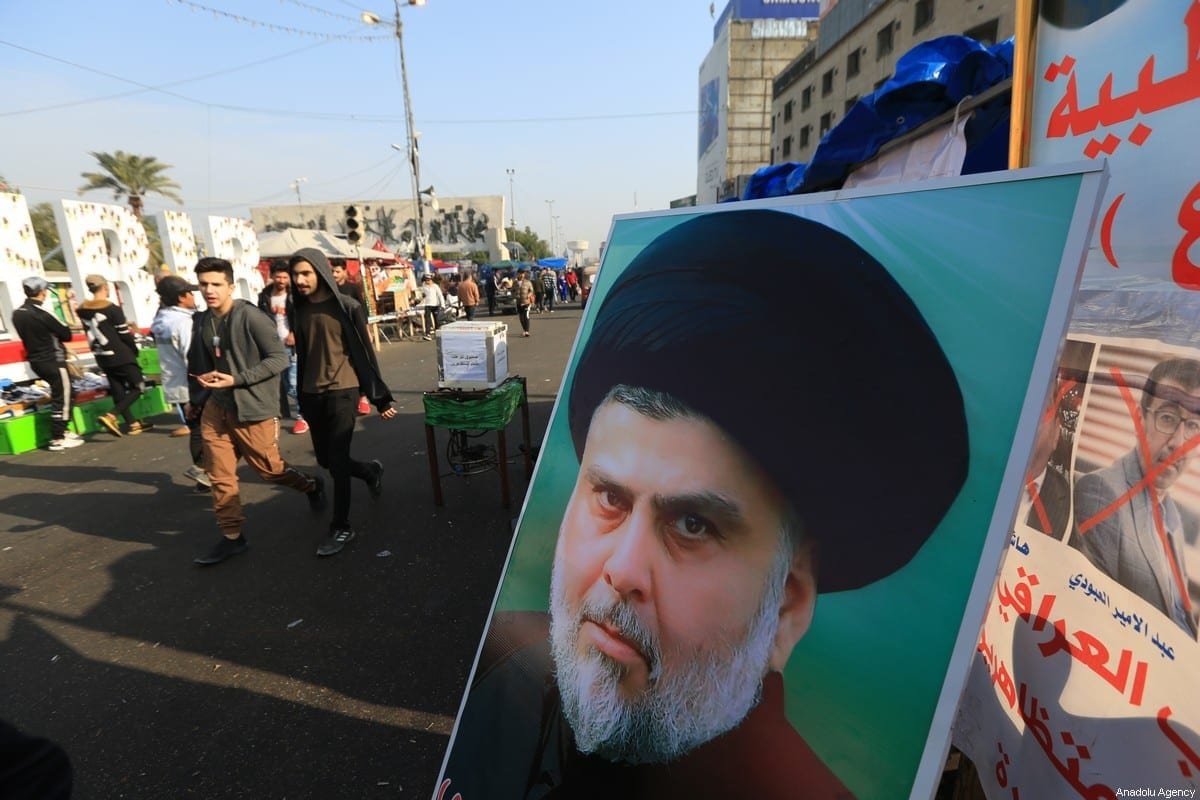 Cartaz do líder do movimento sadrista, Muqtada Al-Sadr, é visto enquanto manifestantes iraquianos se reúnem na Praça Tahrir em Bagdá, Iraque, em 3 de janeiro de 2020. [Murtadha Sudani/Anadolu Agency]