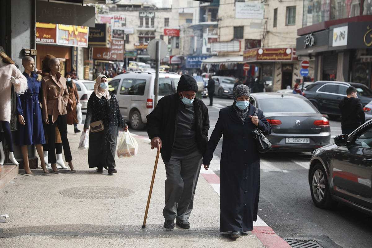 Palestinos usam mascaras como medida contra o novo tipo de coronavírus (Covid-19) pandemia em Ramallah, Cisjordânia em 30 de janeiro de 2021 [Issam Rimawi / Agência Anadolu]
