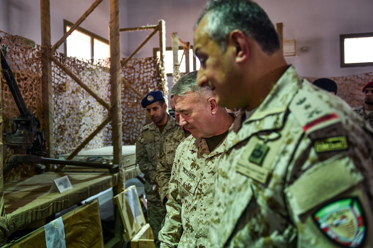 Da frente para o fundo, o tenente-general Fahd bin Turki bin Abdulaziz al-Saud), comandante das forças de coalizão lideradas pela Arábia Saudita no Iêmen, o comandante do Comando Central dos EUA (Centcom), McKenzie Jr,  e  o general do Corpo de Fuzileiros Navais dos EUA, Kenneth F ,  observam armas supostamente iranianas apreendidas pelas forças sauditas dos rebeldes houthis do Iêmen, durante visita a uma base militar em al-Kharj, no centro da Arábia Saudita, em 18 de julho de 2019. [Fayez Nureldine/ AFP via Getty Images]
