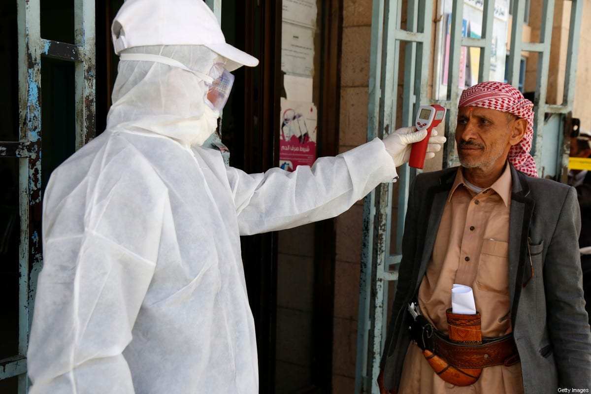Profissional de saúde mede a temperatura de um homem como medida preventiva para combater o covid-19, em uma instalação pública em Sanaa, capital do Iêmen, 24 de março de 2020 [Mohammed Hamoud/Getty Images]