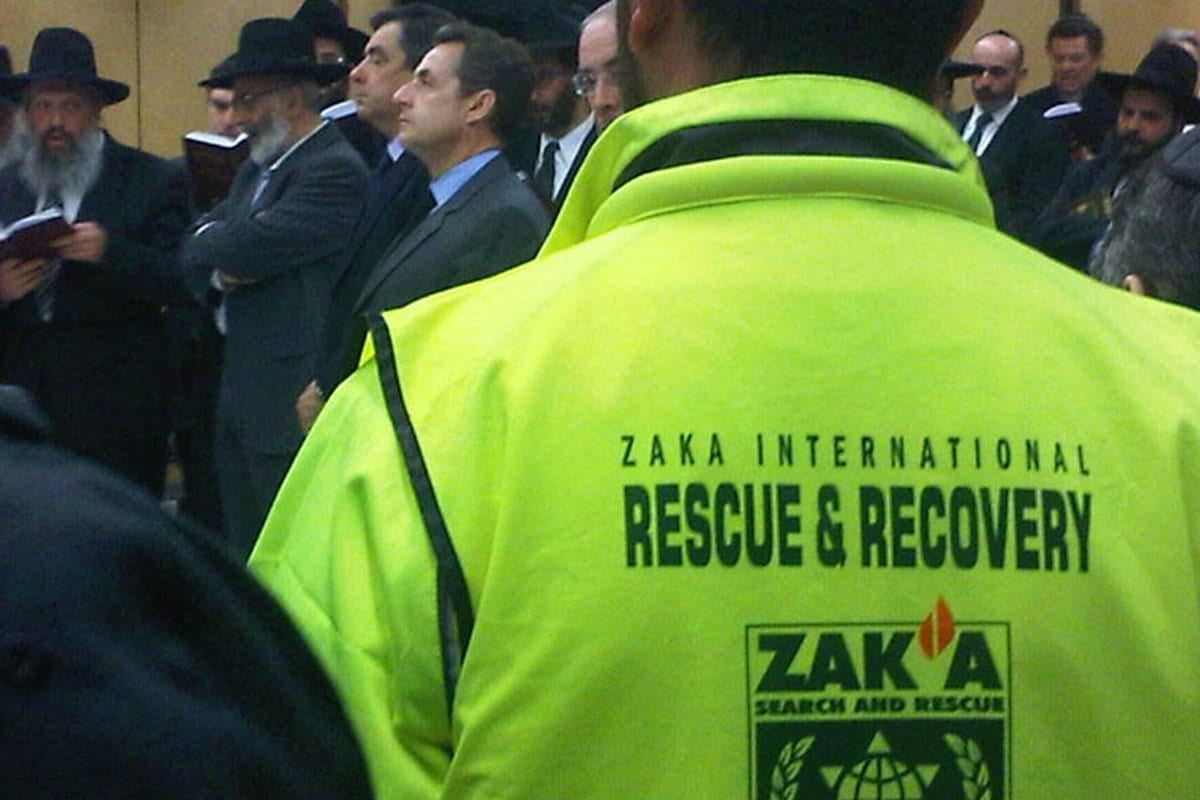 Imagem de divulgação fornecida pela organização Zaka, um homem usa uma jaqueta com a insígnia da organização,  em uma cerimônia em Paris, França, em 20 de março de 2012, [Zaka via Getty Images]
