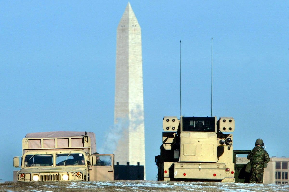 Soldados do exército dos EUA manejam um sistema de mísseis Avenger posicionado em uma colina em 13 de fevereiro de 2003 em Washington, DC com o Monumento a Washington ao fundo. [Mark Wilson/ Getty Images]