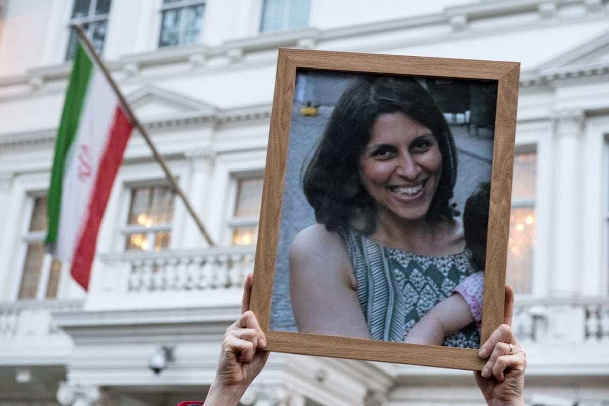 Apoiadores seguram uma foto de Nazanin Zaghari-Ratcliffe durante uma vigília pela mãe britânico-iraniana presa em Teerã em frente à Embaixada do Irã, em 16 de janeiro de 2017 em Londres, Reino Unido. [Chris J Ratcliffe/Getty Images]