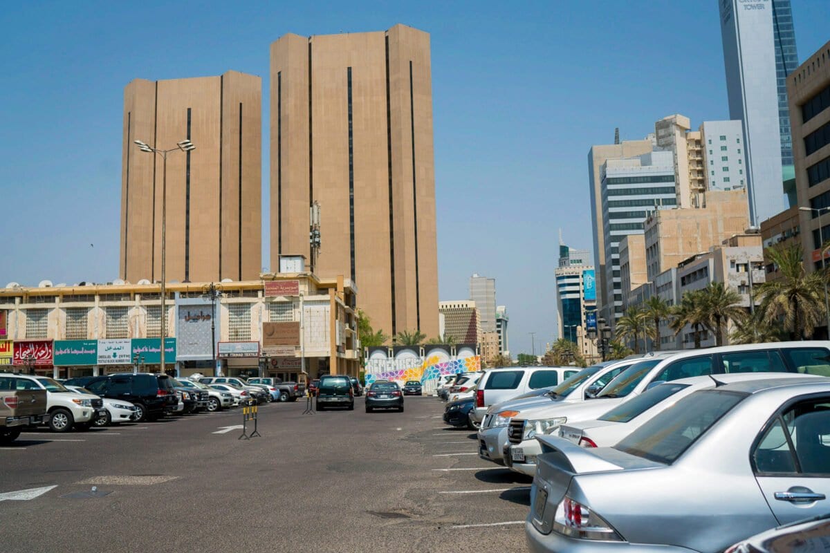 Automóveis parados em um estacionamento perto de lojas de varejo e torres de escritórios na Cidade do Kuwait, Kuwait, no domingo, 13 de agosto de 2017 [Tasneem Alsultan / Bloomberg via Getty Images]