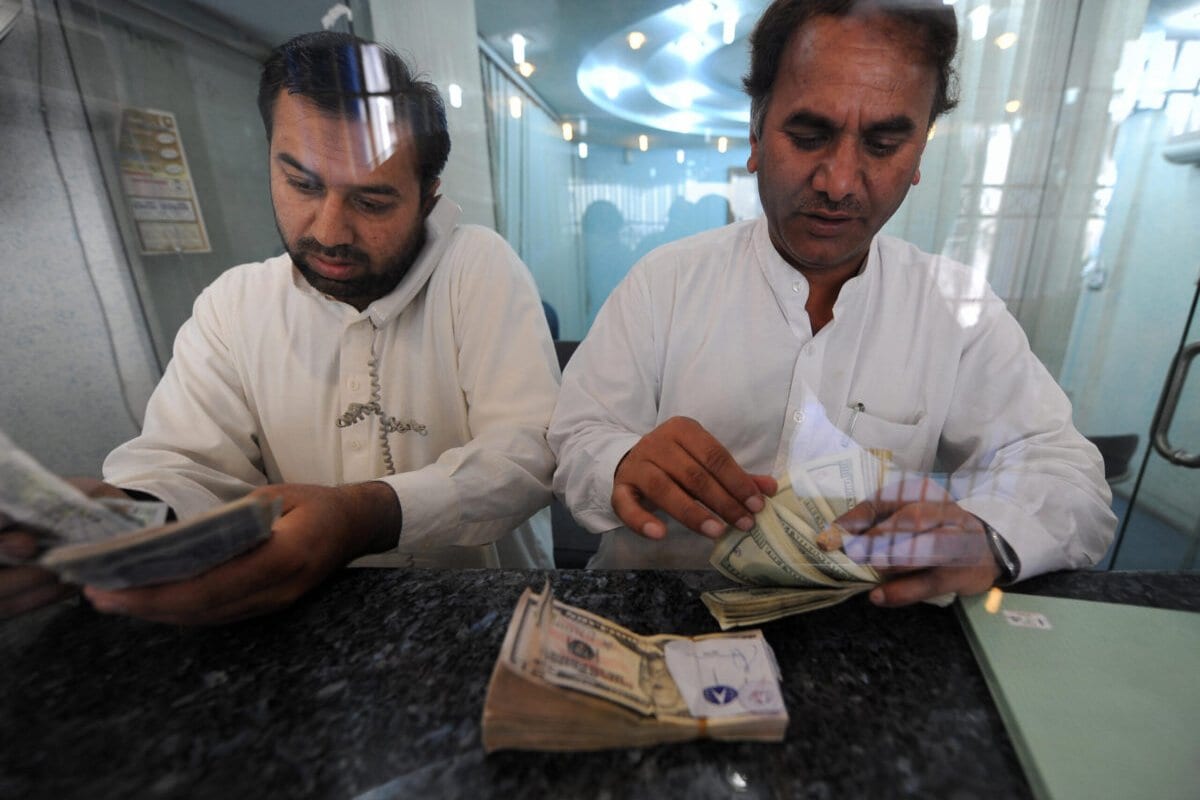 Negociadores contam dólares americanos e outras notas monetárias no mercado financeiro em 20 de abril de 2009 [AAMIR QURESHI / AFP via Getty Images]