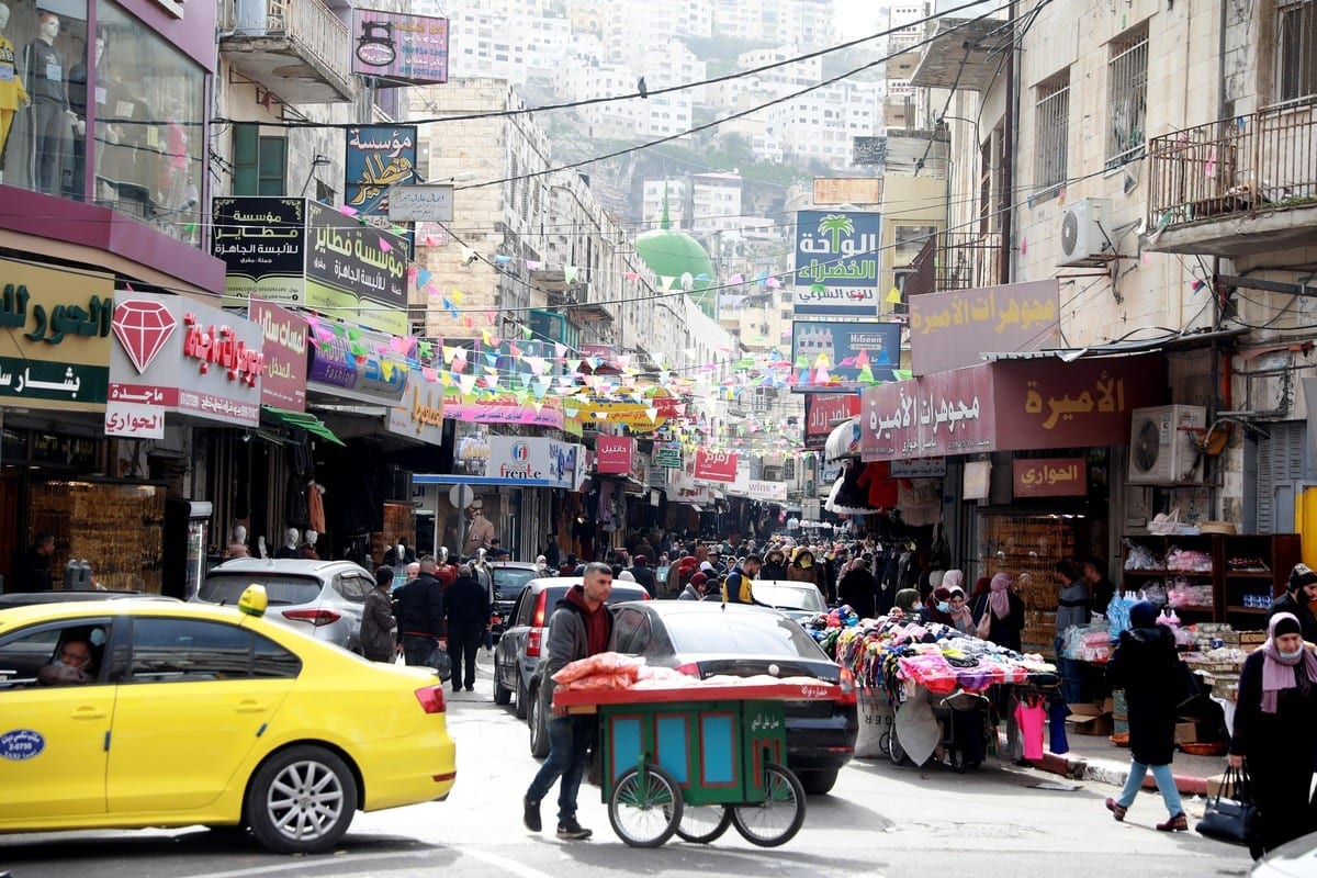 Palestinos compram em um mercado em Ramallah, Cisjordânia, em 30 de janeiro de 2021 [Issam Rimawi / Anadolu]
