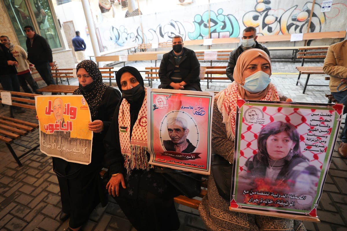 Palestinos protestam em frente à sede do Comitê Internacional da Cruz Vermelha contra as violações israelenses perpetradas aos prisioneiros palestinos, na Faixa de Gaza, 15 de fevereiro de 2021 [Mustafa Hassona/Agência Anadolu]