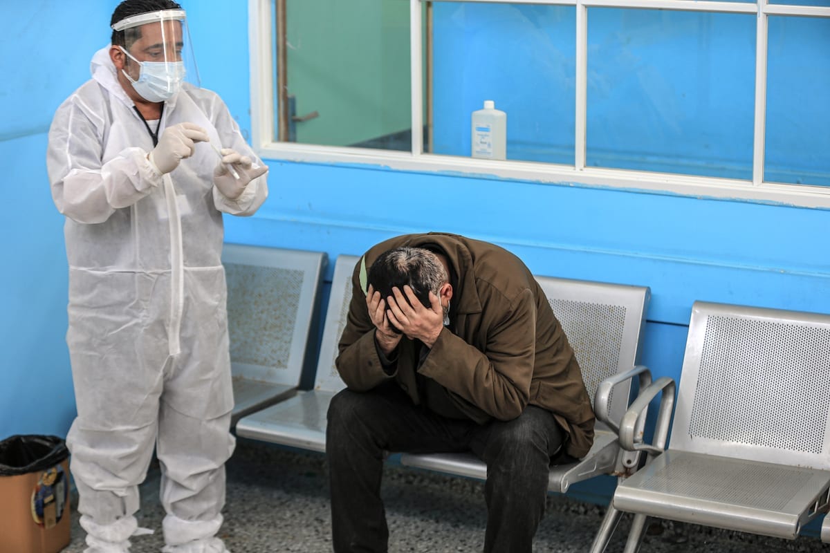  Atendente e usuário do serviço de covid-19 no Hospital Al-Shifa na Cidade de Gaza, Gaza em 6 de abril, 2021 [Agência Ali Jadallah / Anadolu]