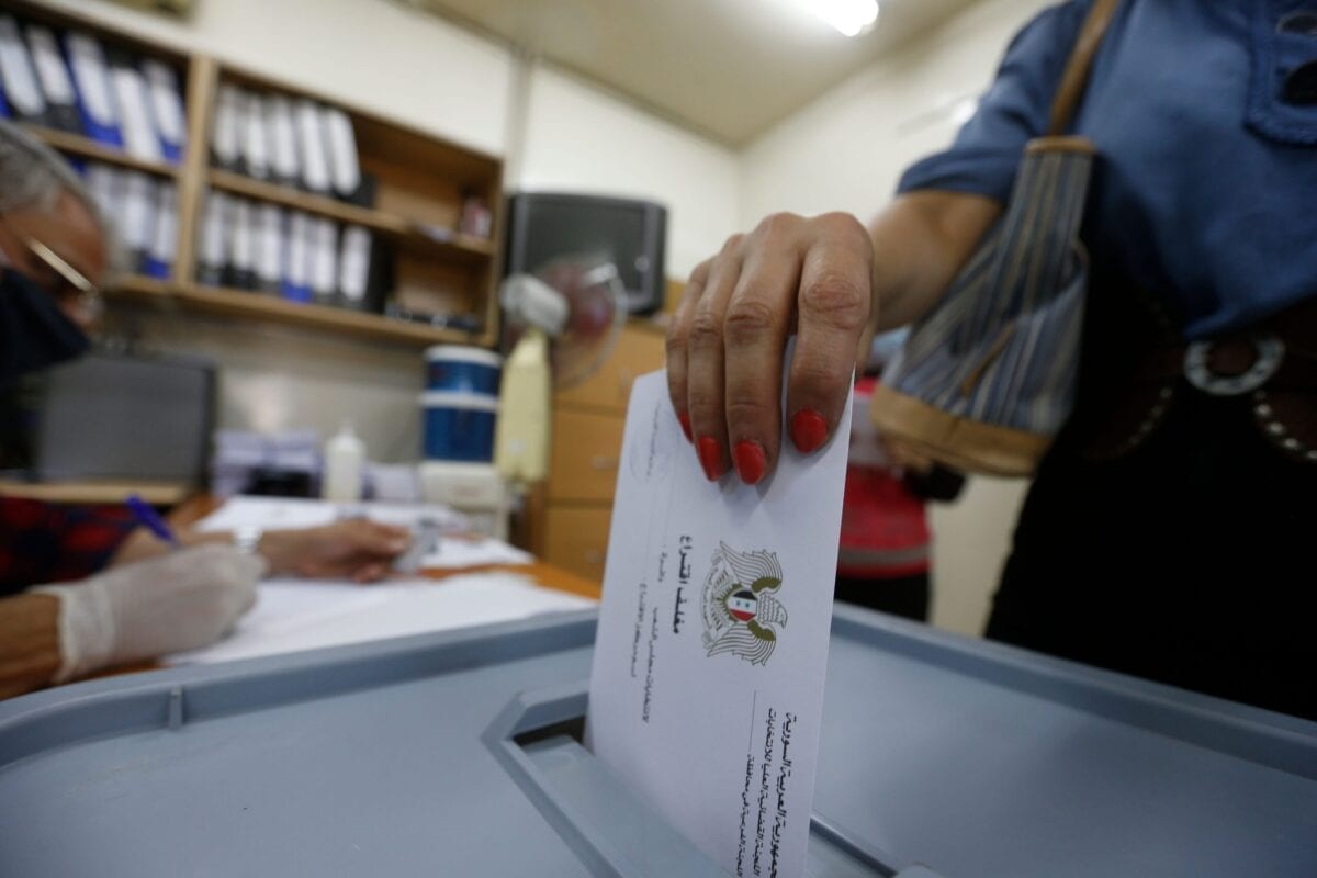 Cidadã síria registra seu voto para o parlamento em um colégio eleitoral de Damasco, em 19 de julho de 2020 [Louai Beshara/AFP via Getty Images]