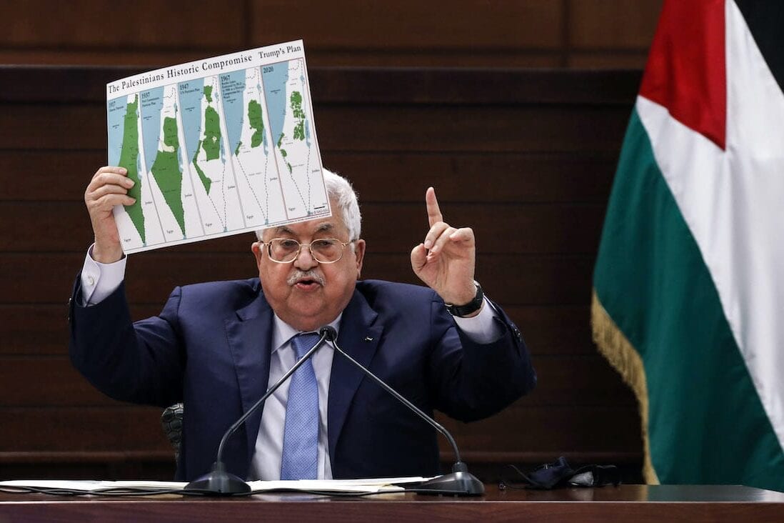 O presidente palestino Mahmud Abbas segura um cartaz mostrando mapas da Palestina histórica [Alaa Badarneh/ Pool/ AFP via Getty Images]
