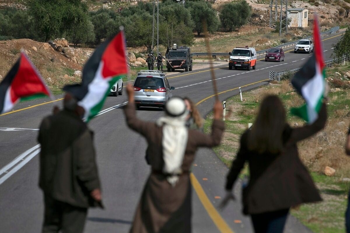 Palestinos bloqueiam uma estrada para impedir a passagem de colonos israelenses durante protesto contra a expansão de assentamentos ilegais exclusivamente judaicos na aldeia de Kafr Malik, na Cisjordânia ocupada, em 20 de novembro de 2020 [Abbas Momani/AFP via Getty Images]