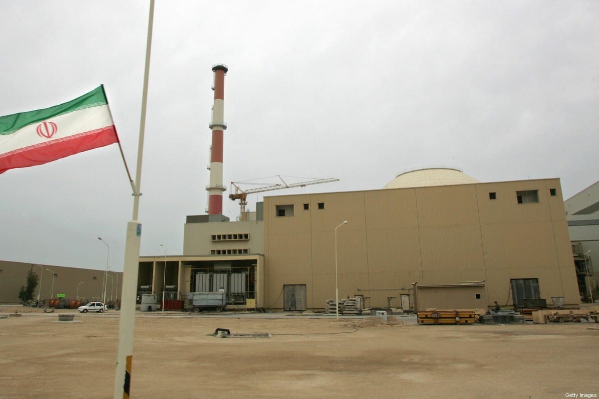 Foto de arquivo datada de 3 de abril de 2007 mostra uma bandeira iraniana fora do prédio que abriga o reator da usina nuclear de Bushehr na cidade portuária de Bushehr, no sul do Irã. [Behrouz Mehri/AFP FILES/AFP via Getty Images]
