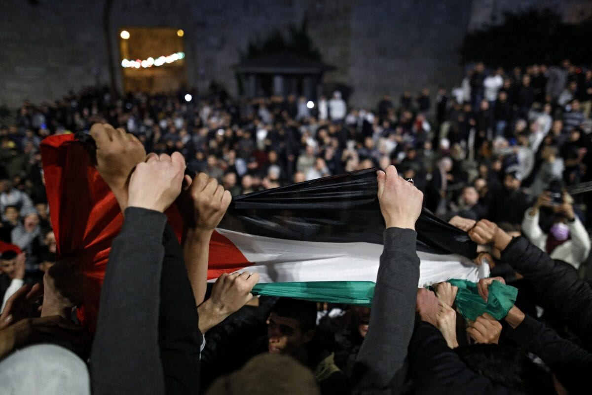 Manifestantes palestinos agitam a bandeira nacional do lado de fora do Portão de Damasco na Cidade Velha de Jerusalém em 26 de abril de 2021 [Ahmad Gharabli/ AFP via Getty Images]
