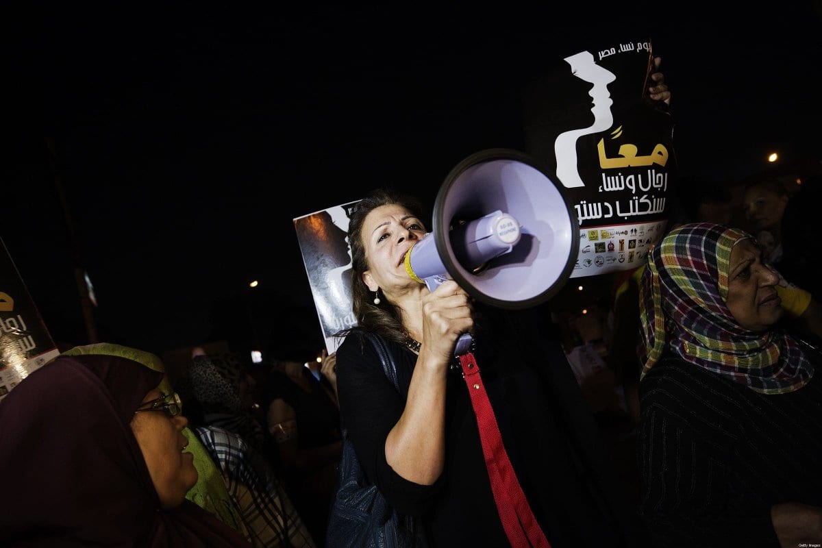 Mulheres e ativistas egípcias seguram slogans que dizem 'Juntos, homens e mulheres, escreveremos nossa constituição', em frente ao palácio presidencial no Cairo, em 4 de outubro de 2012 [Gianluigi Guercia/AFP/Getty Images]
