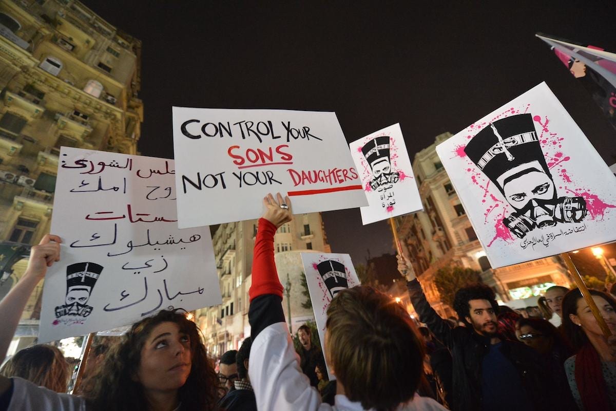 Manifestantes egípcios seguram cartazes e gritam slogans durante uma manifestação no Cairo contra o assédio sexual, em 12 de fevereiro de 2013 [Khaled Desouki/AFP via Getty Images]