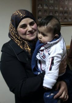 Dallal Ziben, de 32 anos, com seu bebê Muhannad, durante coletiva de imprensa para anunciar o êxito de operações de inseminação artificial após contrabandear amostras de esperma de quatro prisioneiros palestinos, na cidade de Nablus, Cisjordânia ocupada, 6 de fevereiro de 2013 [Nedal Eshtayah/Apaimages]