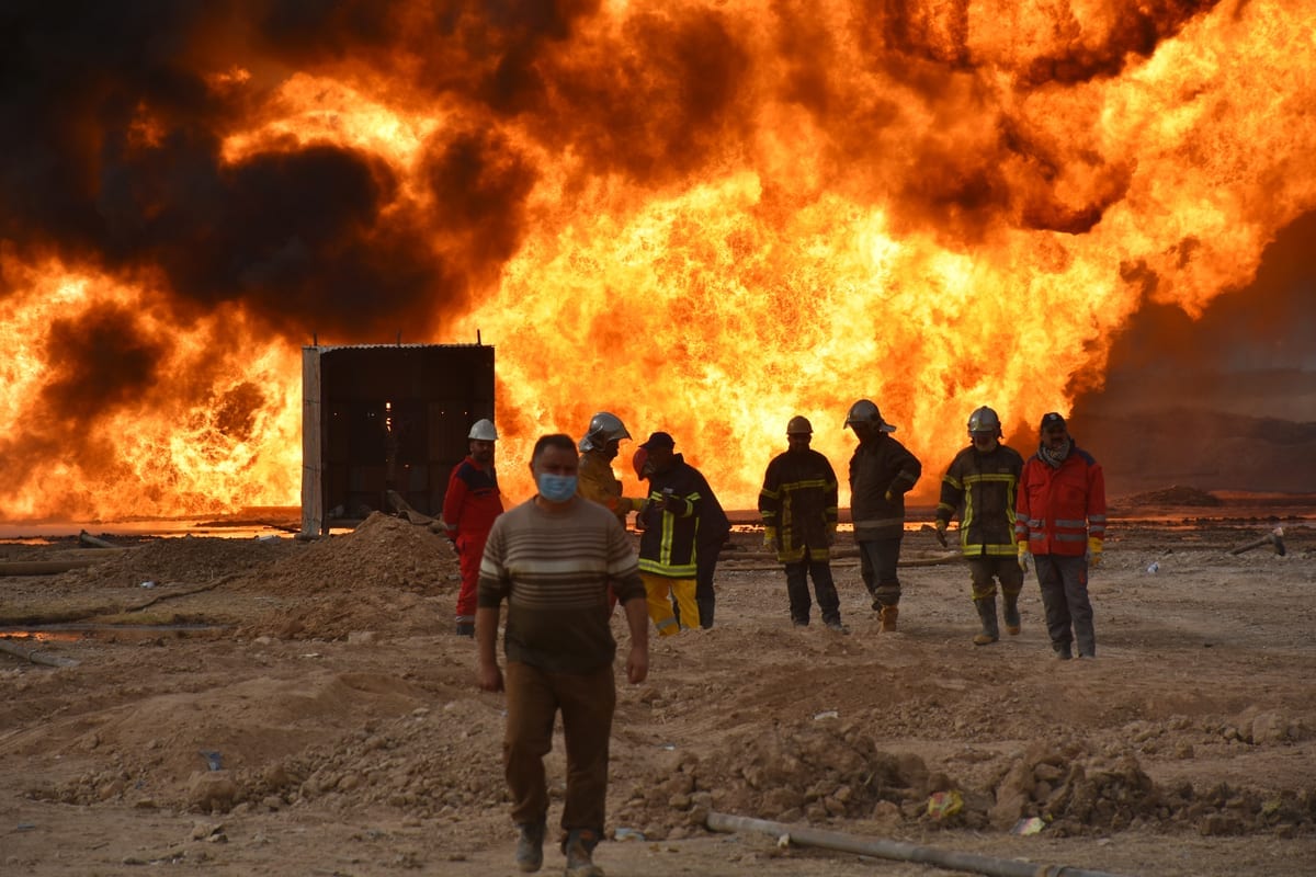 Equipes de bombeiros realizam trabalhos de extinção após o Daesh realizar um ataque a bomba contra poços no campo de petróleo Habbaza, na província de Kirkuk, no Iraque, em 15 de dezembro de 2020 [Ali Makram Ghareeb/Agência Anadolu]
