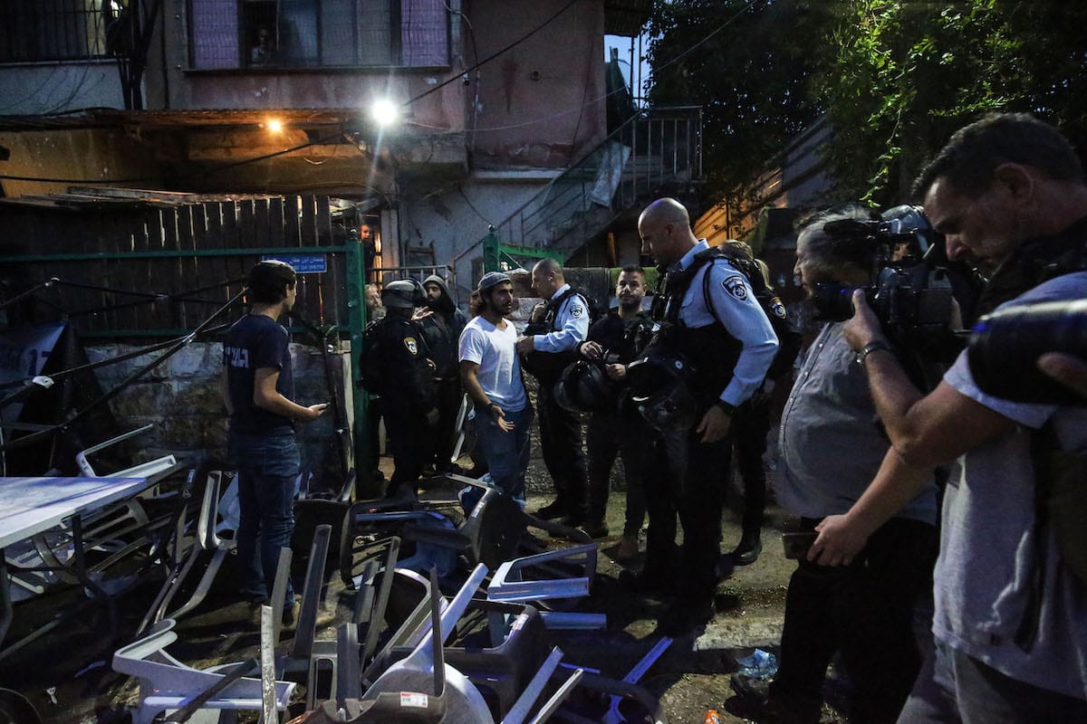 Colonos ilegais israelenses atiram objetos contra famílias palestinas dos telhados de casas ocupadas em Sheikh Jarrah, no momento do jantar do Ramadã, mês sagrado islâmico marcado pela prática do jejum; Israel quer expulsar os residentes árabes de suas casas, em Jerusalém Oriental, 6 de maio de 2021 [Mostafa Alkharouf/Agência Anadolu]