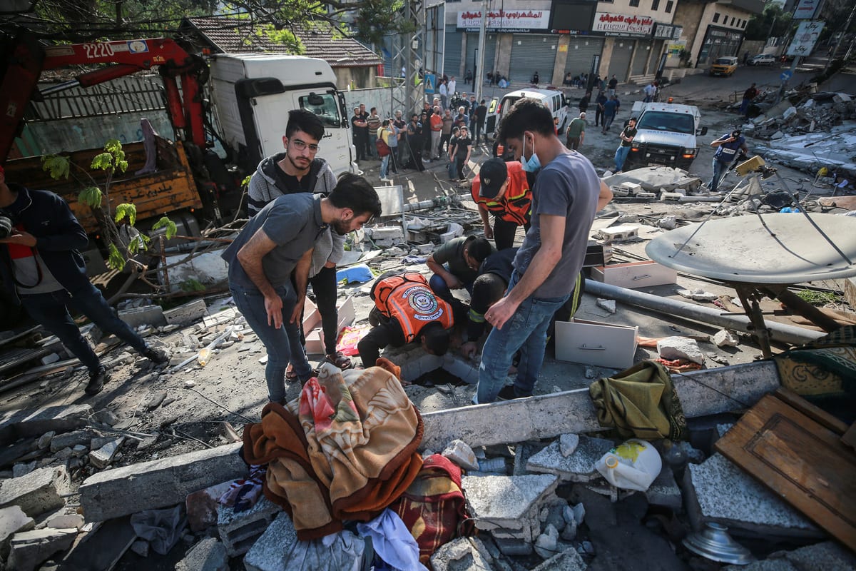 Operações de busca e resgate após ataques aéreos do exército israelense atingirem edifícios residenciais em Gaza, 16 de maio de 2021 [Mustafa Hassona/Agência Anadolu]