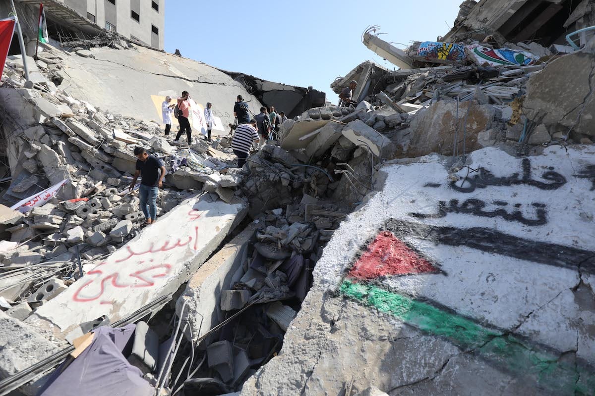 Artista palestino desenha murais nas ruínas da Torre al-Shurouk, em Gaza, para expressar a resistência de seu povo, 25 de maio de 2021 [Mohammed Asad/Monitor do Oriente Médio]

