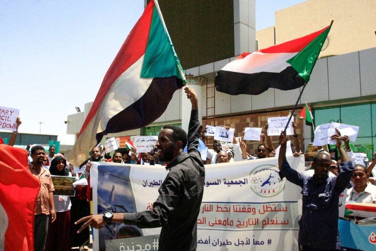 Sudanês agitam bandeiras nacionais em 27 de maio de 2019 [Ebrahim Hamid/ AFP/ Getty]