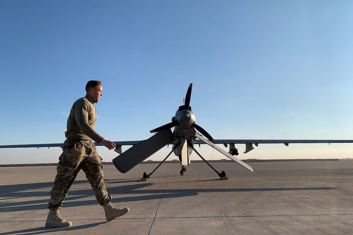 Soldado dos Estados Unidos passa por um drone militar na base aérea de Ain al-Asad, na província de Anbar, oeste do Iraque, 13 de janeiro de 2020 [Ayman Henna/AFP via Getty Images]
