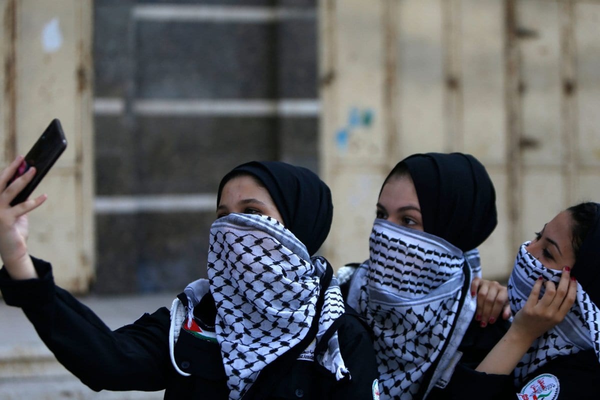 Jovens palestinas vestem o lenço tradicional (keffiyeh) como máscara de proteção contra o covid-19 na Cidade de Gaza, 22 de junho de 2020 [Mohammed Abed/AFP/Getty Images]
