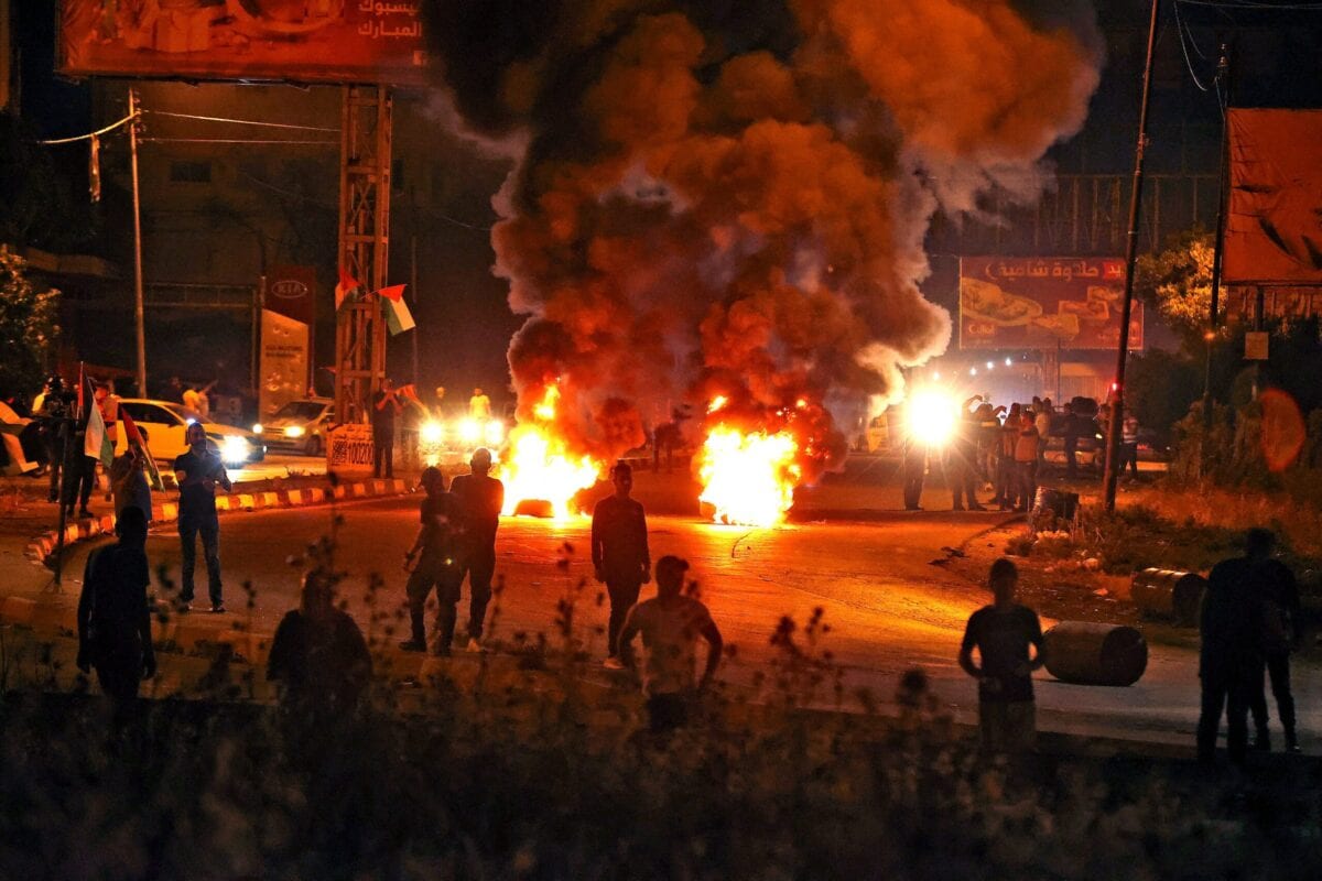 Manifestantes palestinos montam barricadas em meio à forte repressão da ocupação israelense, no posto de controle de Hawara, ao sul da cidade de Nablus, Cisjordânia ocupada, 8 de maio de 2021 [Jaafar Ashtiyeh/AFP via Getty Images]