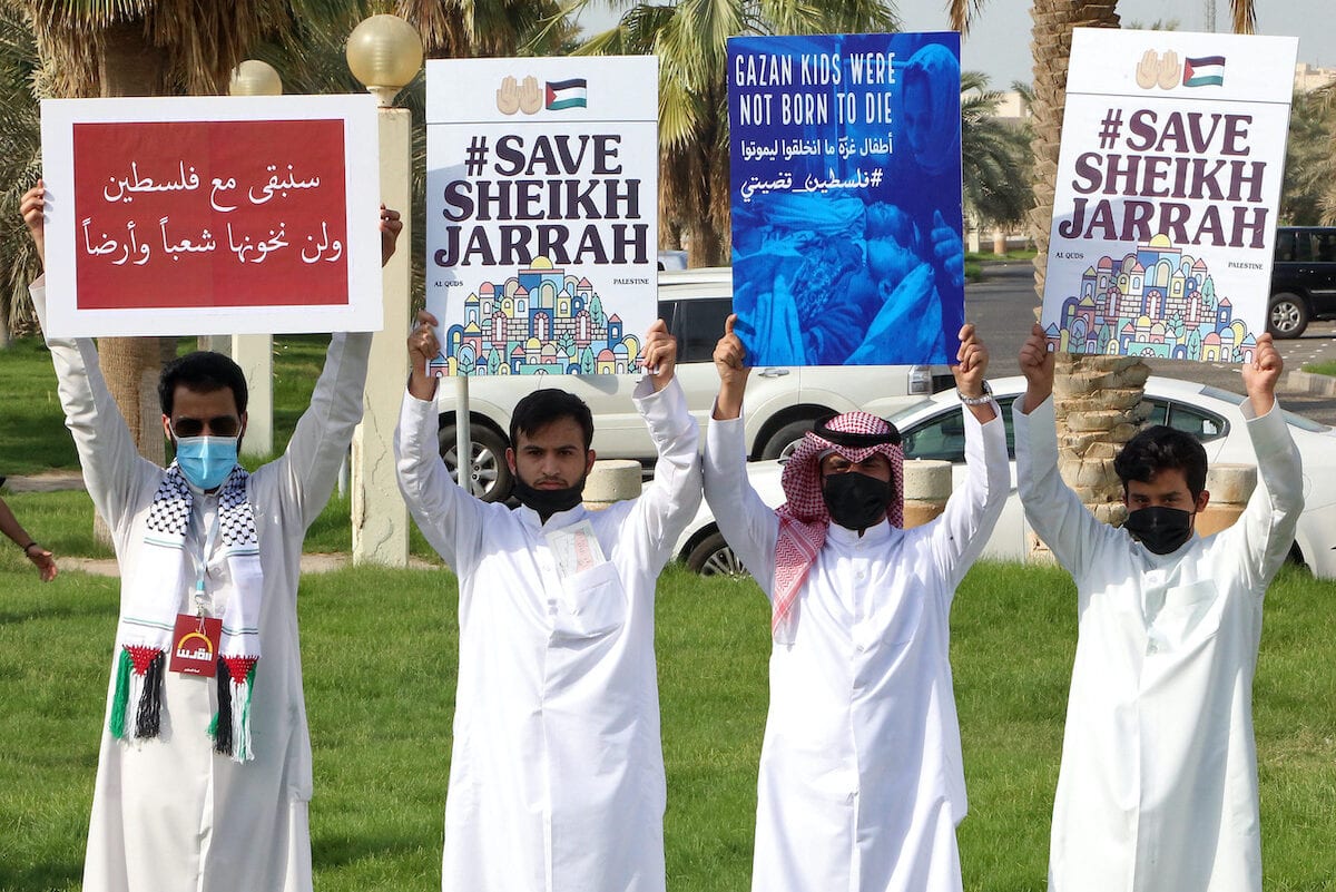Kuwaitianos seguram cartazes durante um protesto em solidariedade ao povo palestino na Cidade do Kuwait em 11 de maio de 2021. [YASSER AL-ZAYYAT / AFP via Getty Images]
