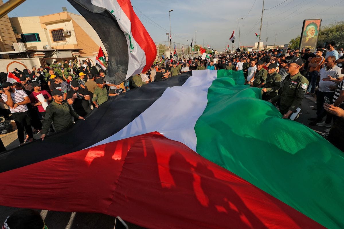 Apoiadores das forças paramilitares Hashed al-Shaabi (Mobilização Popular) com uma bandeira
palestina durante manifestação na capital Bagdá, Iraque, 20 de maio de 2021 [Ahmad al-Rubaye/AFP via
Getty Images]