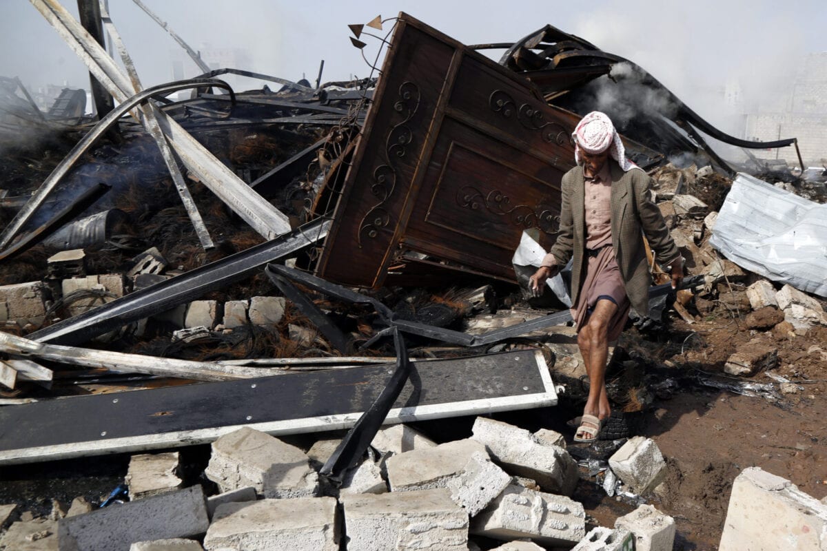 Homem caminha sobre os escombros de uma borracharia atingida por ataques aéreos executados pela coalizão saudita, em Sanaa, capital do Iêmen, 2 de julho de 2020 [Mohammed Hamoud/Getty Images]