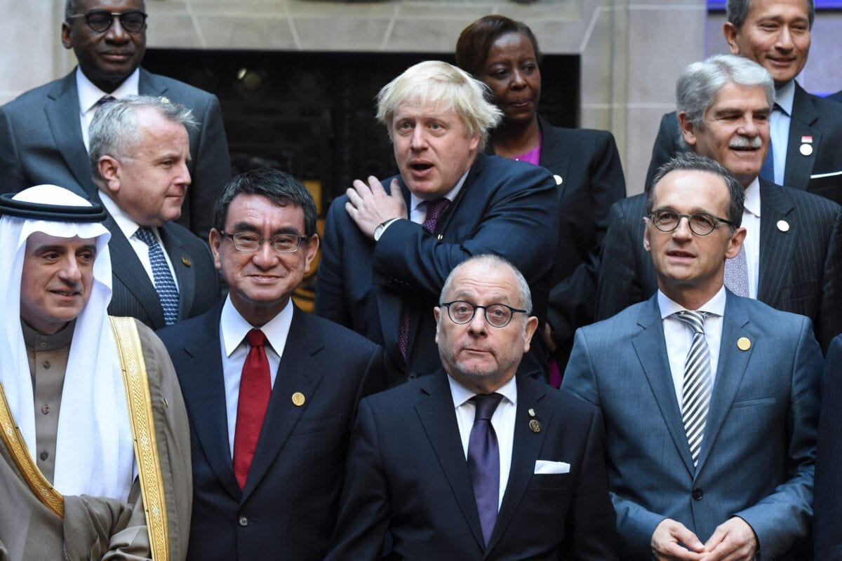 Em seguida, o secretário de Estado britânico de Relações Exteriores, Boris Johnson (C) gesticula ao lado do vice-secretário de Estado dos Estados Unidos, John Sullivan (E), durante uma foto de família no encontro de chanceleres do G20 no Palácio San Martin de Buenos Aires, em maio 21, 2018 [EITAN ABRAMOVICH / AFP via Getty Images]