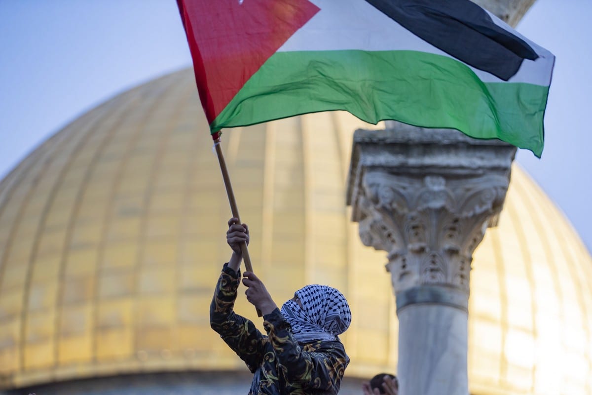 Um homem palestino agita a bandeira palestina no Complexo Al-Aqsa em Jerusalém em 13 de maio de 2021 [Agência Mostafa Alkharouf / Anadolu]
