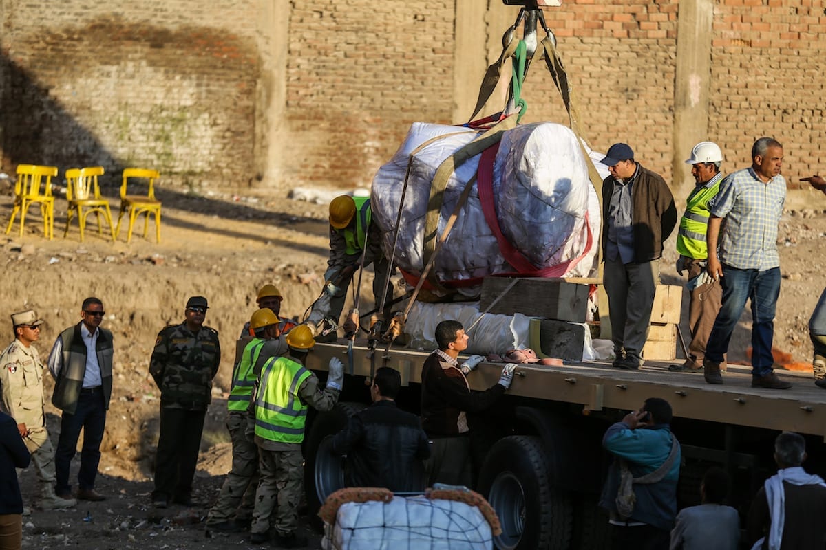 Partes de pedra de uma enorme estátua, possivelmente simbolizando Ramsés II, estão sendo carregadas em um caminhão e enviadas ao museu egípcio depois de serem descobertas no antigo sítio arqueológico de Heliópolis no distrito de Matareya, no Cairo, Egito, em 15 de março de 2017 [İbrahim Ramadan/Agência Anadolu]
