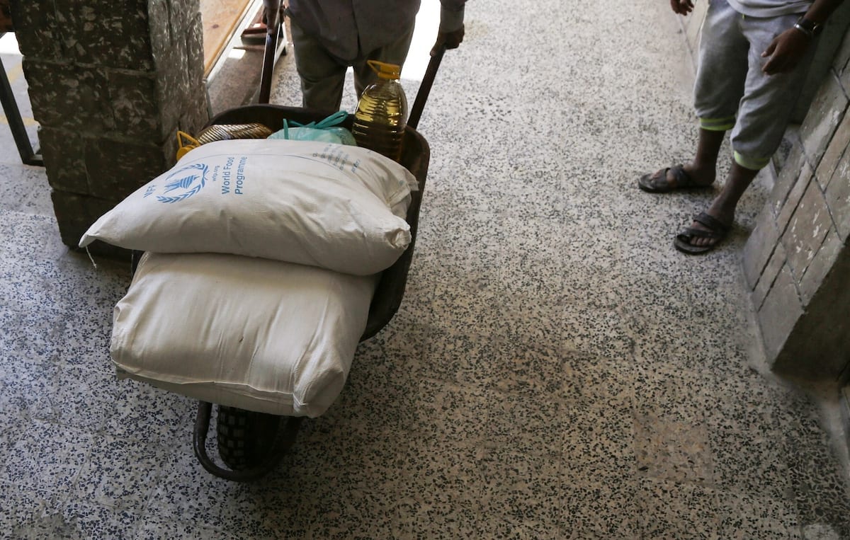 Ajuda alimentar enviada pelo Programa Mundial de Alimentos (PMA) está sendo distribuída para pessoas carentes na capital do Iêmen, Sanaa, em 3 de junho de 2020 [Mohammed Hamoud/Agência Anadolu]
