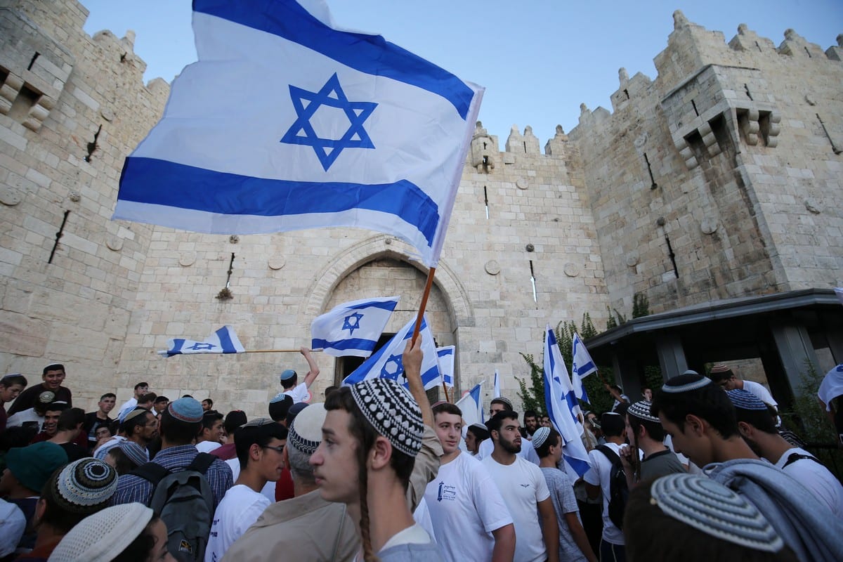 Os israelenses de extrema direita realizam a 'Marcha de Bandeira' em frente ao Portão de Damasco em Jerusalém, em 15 de junho de 2021 [Mostafa Alkharouf/Agência Anadolu]
