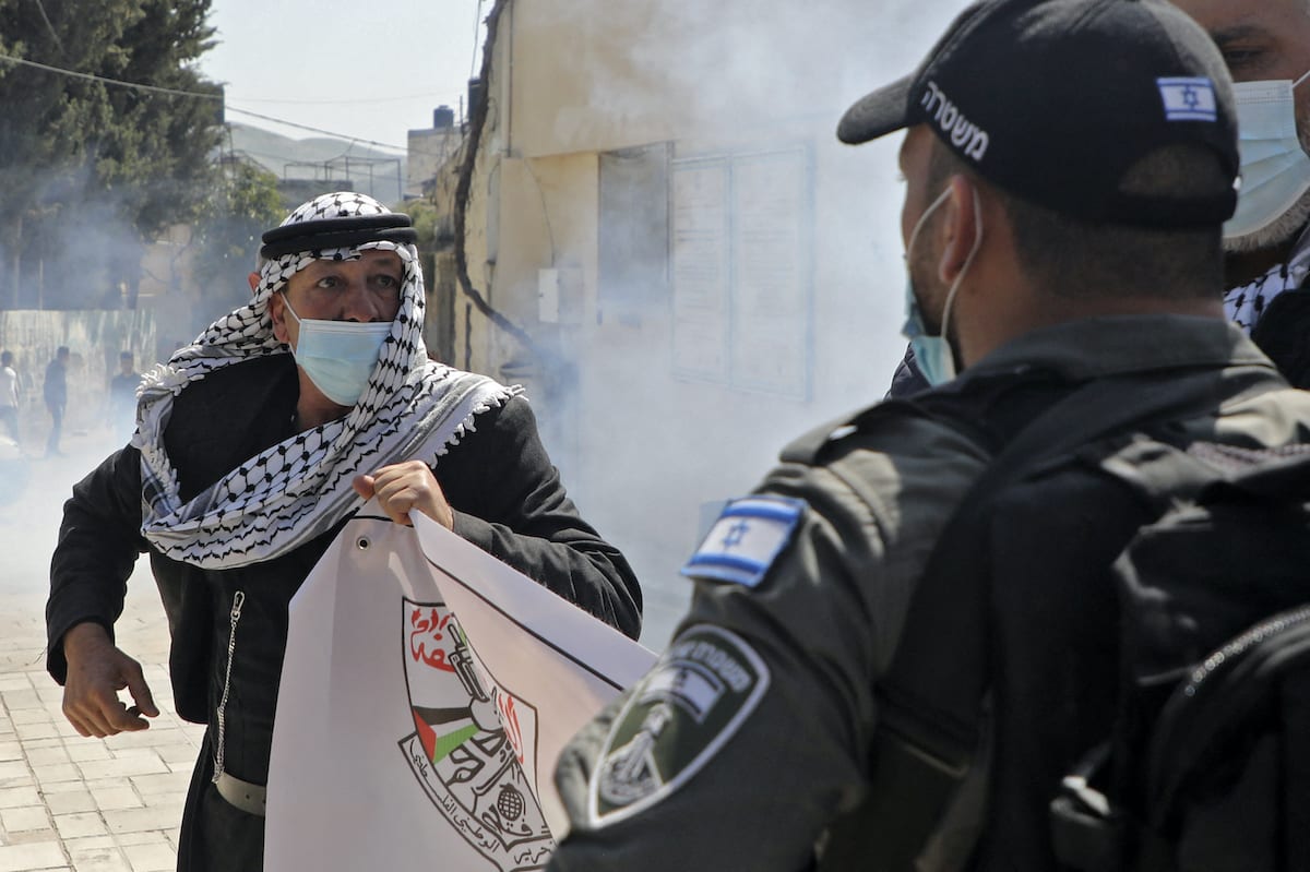 Membros da segurança israelense entram em confronto com manifestantes palestinos comemorando o dia da terra e protestando contra as visitas de colonos a sítios arqueológicos e históricos na vila palestina de Sebastia, a noroeste de Nablus, na Cisjordânia ocupada, em 30 de março de 2021 [Jaafar Ashtiyeh/AFP via Getty Images]