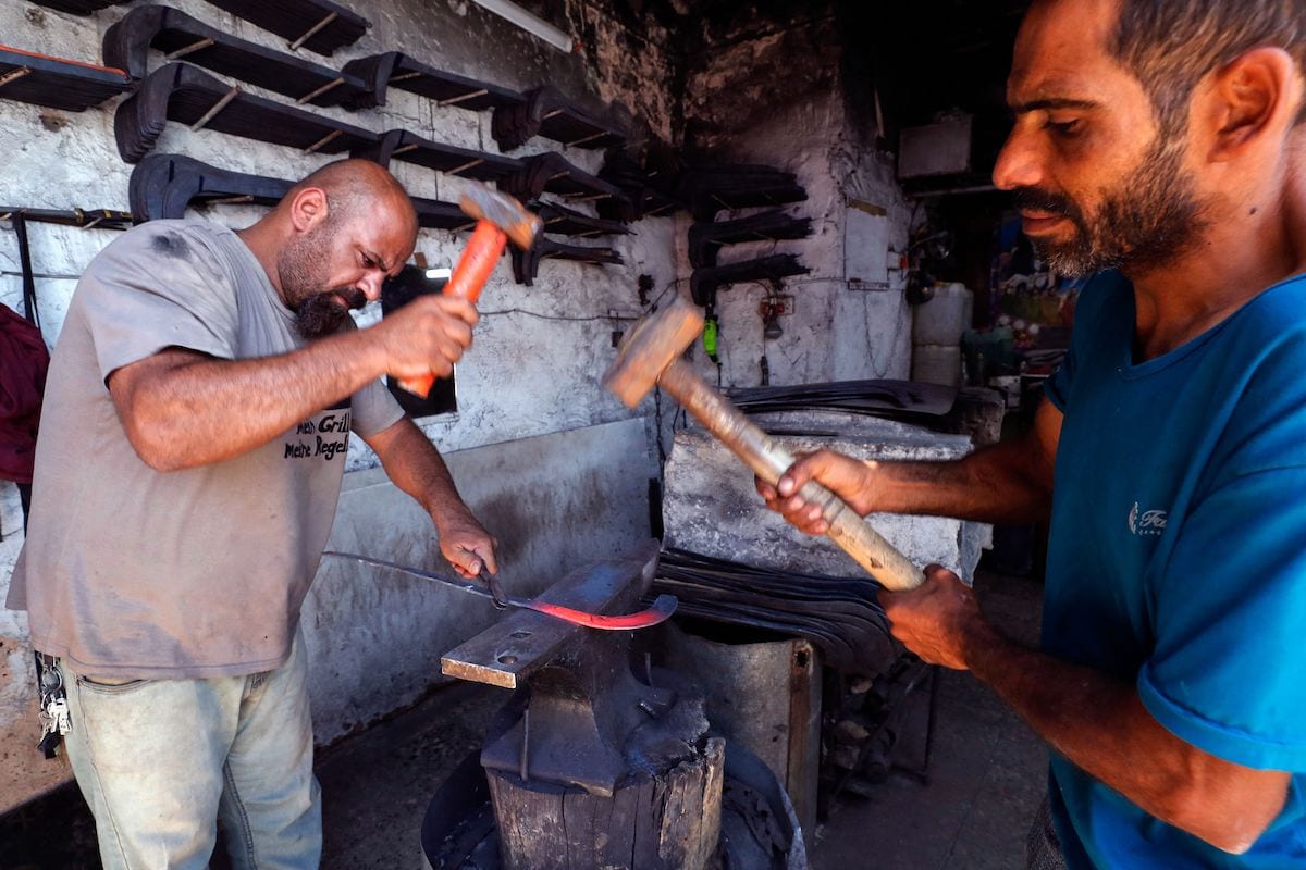 Ferreiros iraquianos fabricam ferramentas agrárias no distrito de al-Alawi, na capital Bagdá, 20 de junho de 2021 [Ahmad al-Rubaye/AFP via Getty Images]

