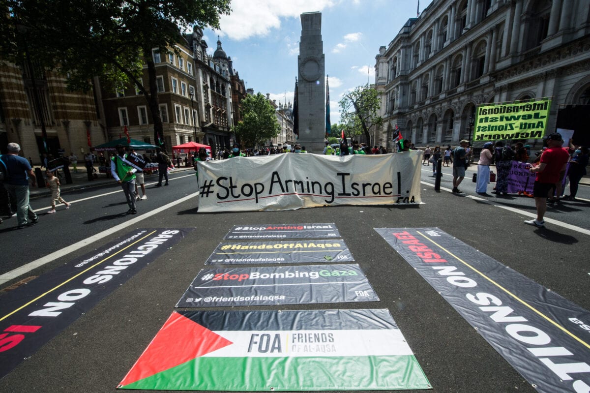 Faixas de protesto são exibidas em uma avenida perto da sede do governo britânico, em Londres, Inglaterra, 12 de junho de 2021 [Guy Smallman/Getty Images]
