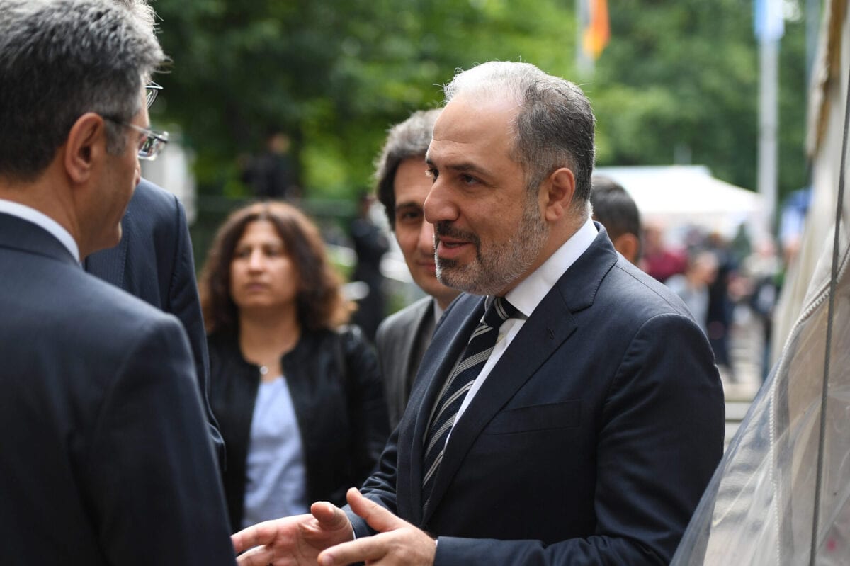 Ali Kemal Aydn (E), embaixador turco na Alemanha, Peter Kuespert (atrás de Aydin), presidente do tribunal constitucional da Baviera, e Mustafa Yeneroglu (D), membro do parlamento turco, conversam fora do Oberlandesgericht, em 11 de julho de 2018, em Munique, Alemanha [Andreas Gebert/Getty Images].
