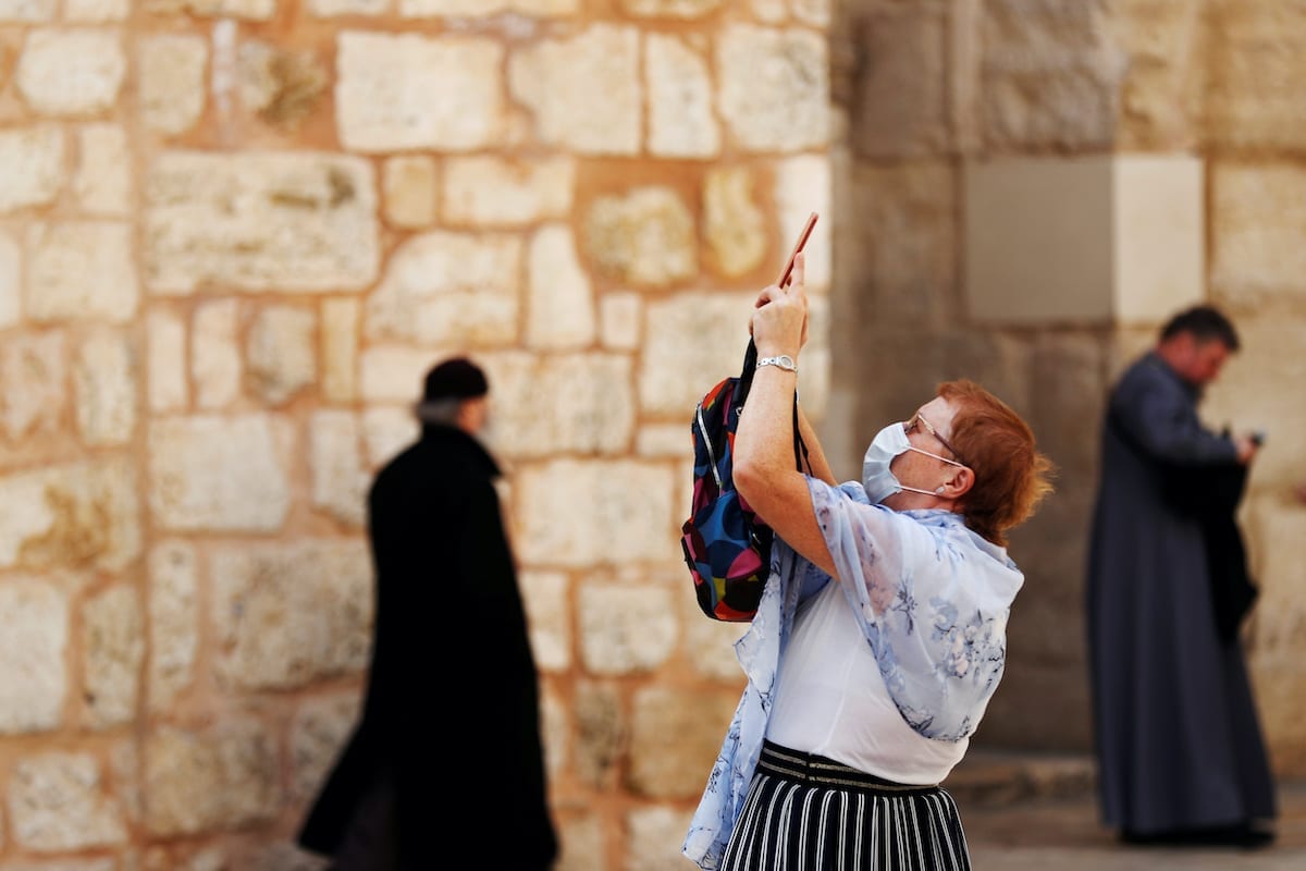 Uma visitante usando uma máscara, como proteção ao coronavírus, na entrada da Igreja do Santo Sepulcro na Cidade Velha de Jerusalém, em 9 de março de 2020 [Reuters/Ronen Zevulun]
