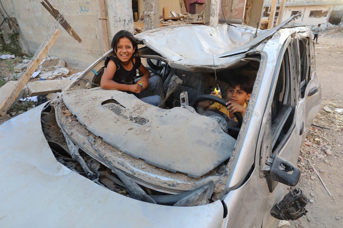 Crianças palestinas são vistas brincando em um carro destruído pelos ataques israelenses em Beit Lahia, Gaza, em 07 de junho de 2021 [Ashraf Amra/Agência Anadolu]
